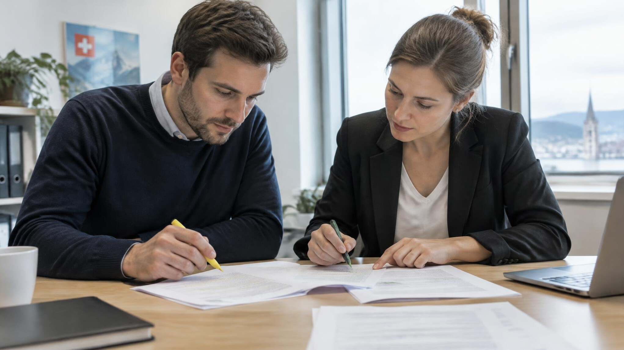 Two colleagues cross-checking documents together at a table